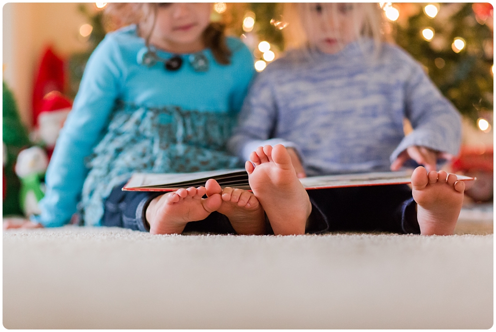 sisters reading books by the Christmas tree